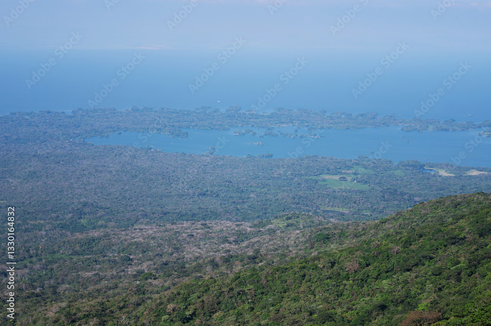 Fototapeta premium Scenic view of lush mountains overlooking serene blue lake at midday