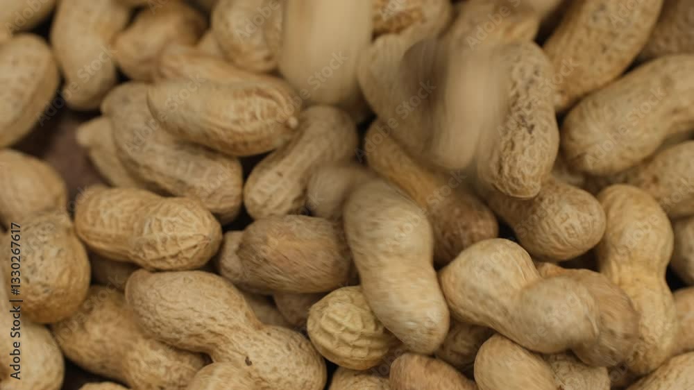 Whole peanuts in shells falling down in wooden bowl Whole peanuts in shells falling down in wooden bowl