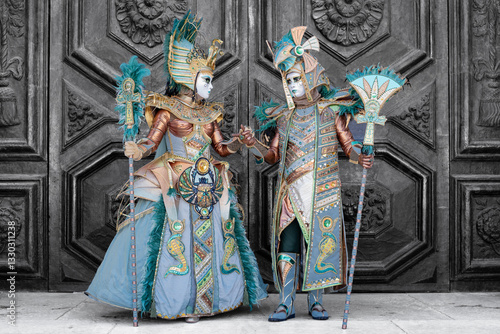 Venetian Carnival Masked Couple in Egyptian-Inspired Costumes on Gray Background

