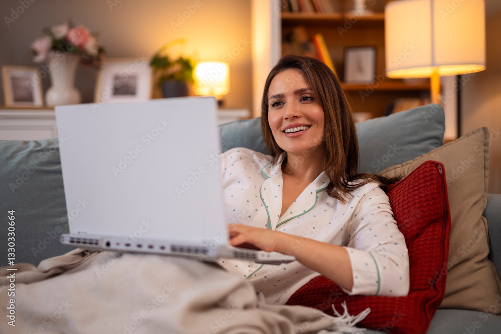 Beautiful woman in pajamas lie on bed and using laptop for work Beautiful woman in pajamas lie on bed and using laptop for work