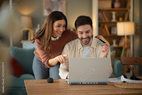 Couple using laptope to buy online. Man holding credit card to pay bills online