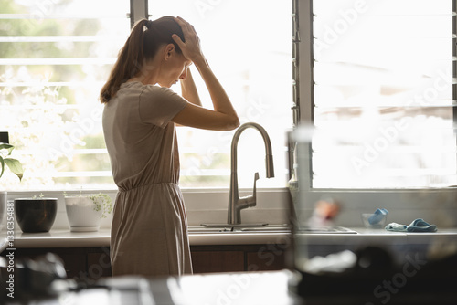 Bild auf Leinwand Depressed overwhelmed mother housewife at home in the kitchen