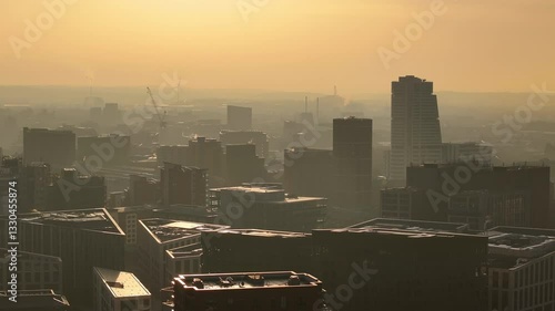 Drone shot of Leeds city centre at dawn. Modern buildings and construction cranes are visible through the morning mist.