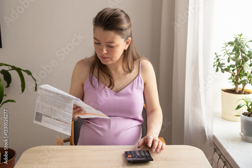 pregnant woman with calculator, computer pays utility bill. Receiving maternity benefits, social payments, maternity capital, donation. pregnancy and childbirth concept. calculate child's birth date