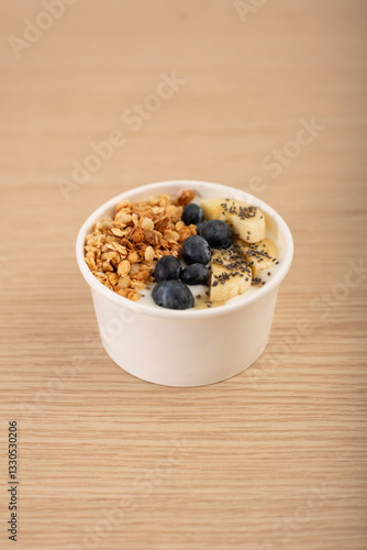 desayuno o comida saludable con fruta, en bol de arandanos, banana, cereal, yogur griego y semillas de chia