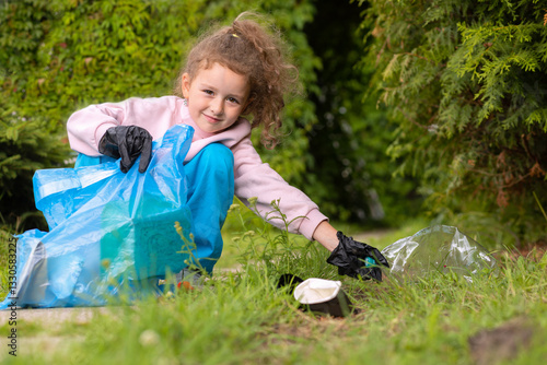 Girl collection plastic garbage in nature. kid picking up trash in park. Earth Day April 22. Save planet. Young volunteer child cleaning forest environment from rubbish pollution. World Environment