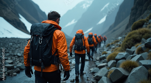 A group of hikers walking through a rocky mountain path.  Overcast day, cold weather.