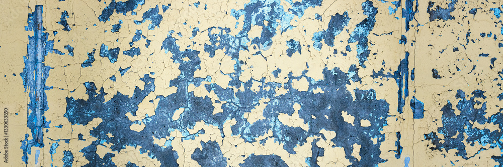 Peeling paint on the wall. Panorama of a concrete wall with old cracked flaking paint. Weathered rough painted surface with patterns of cracks and peeling. Panoramic texture for background and design.