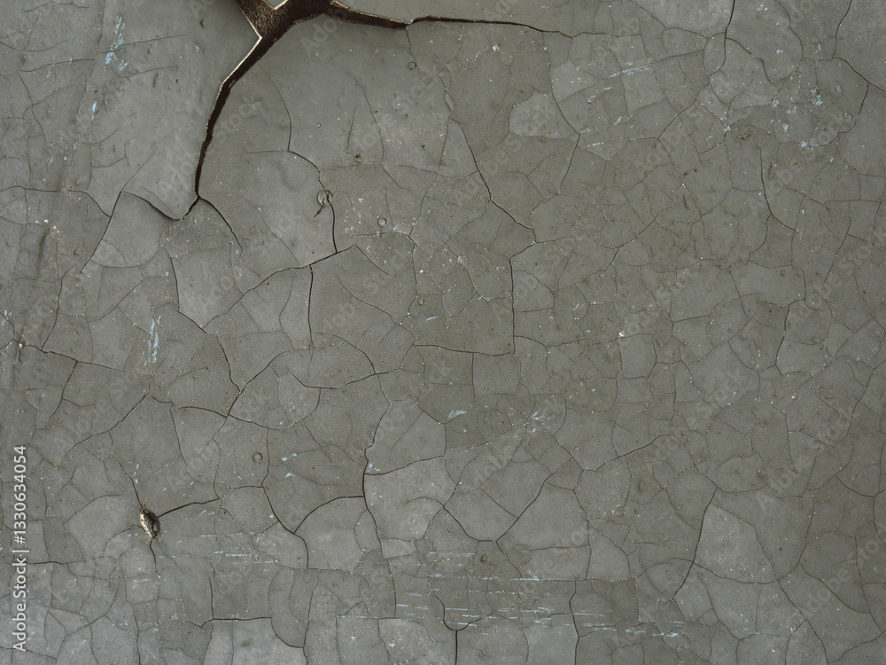 Peeling paint on the wall. Old concrete wall with cracked flaking paint. Weathered rough painted surface with patterns of cracks and peeling. Grunge texture for background and design. Closeup