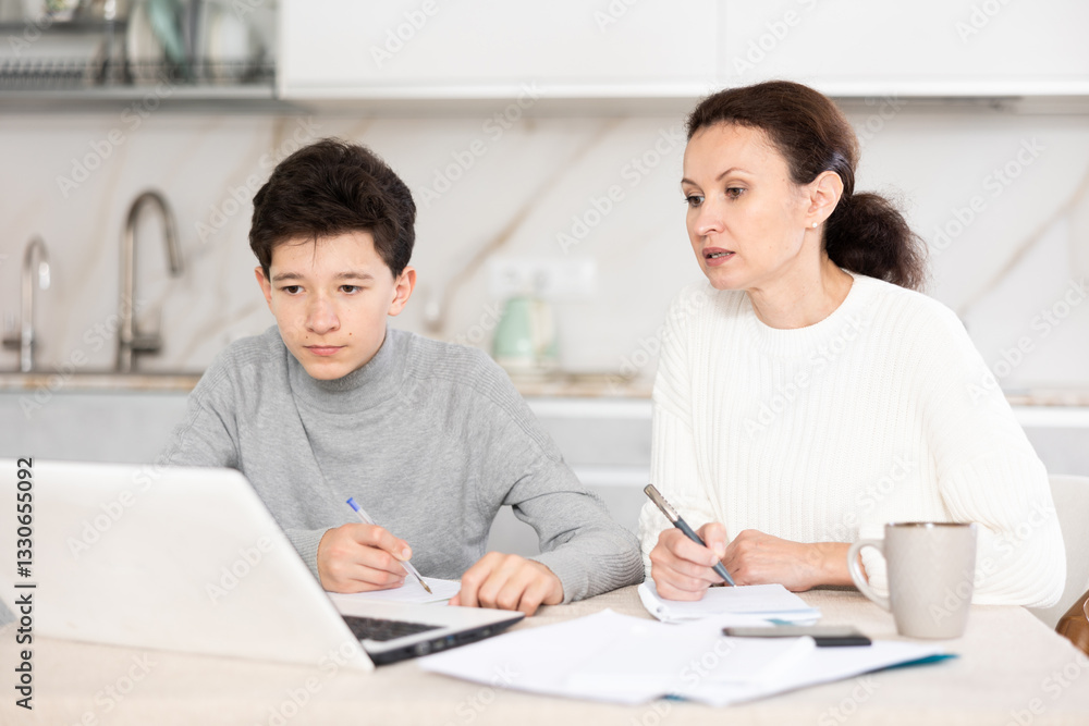 Boy and mother studiyng and learning together using laptop Boy and mother studiyng and learning together using laptop