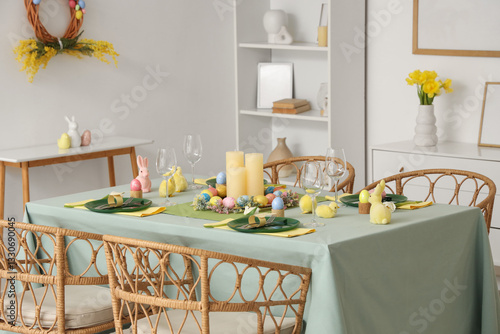 Beautiful table setting with decorative bunnies and Easter eggs in dining room