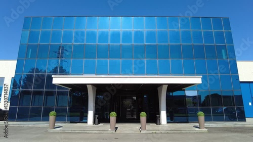 A low office building with blue windows. Sunny weather, clear sky