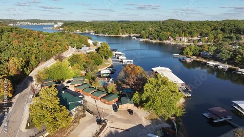Aerial view, flying over the river, forest, small houses on the water and hotels. Missouri, Ozark In summer, green trees, landscape. Drone 4K