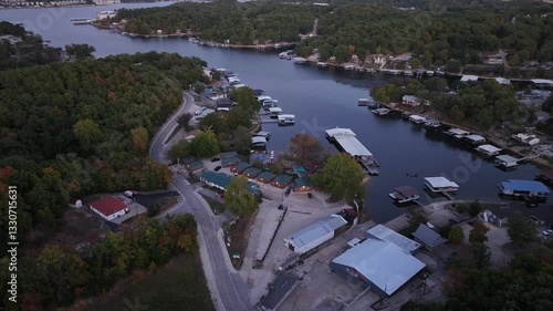 Aerial view, flying over the river, forest, small houses on the water and hotels. Sunset Missouri, Ozark In summer, green trees, landscape. Drone 4K
