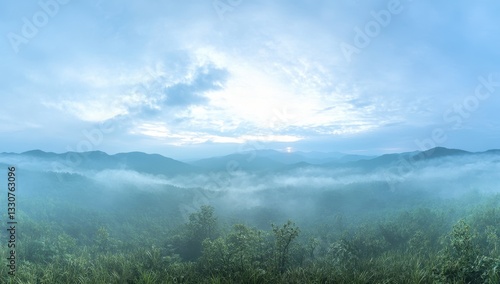 Serene Misty Landscape at Dawn Over Rolling Hills with Soft Fog in the Valley and Cloudy Blue Sky in the Early Morning Light