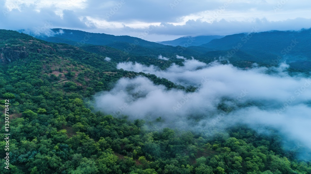An aerial view shows mountains with layers of fog and trees An aerial view shows mountains with layers of fog and trees