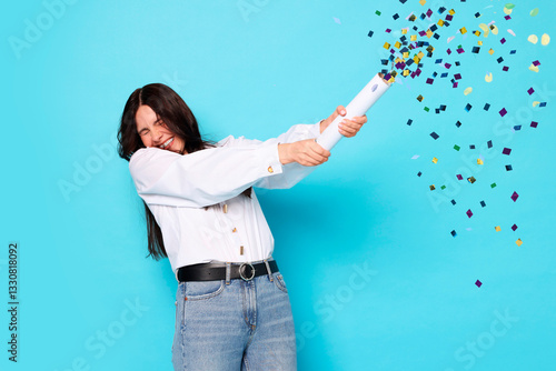Φωτογραφία Happy woman blowing up confetti popper on light blue background