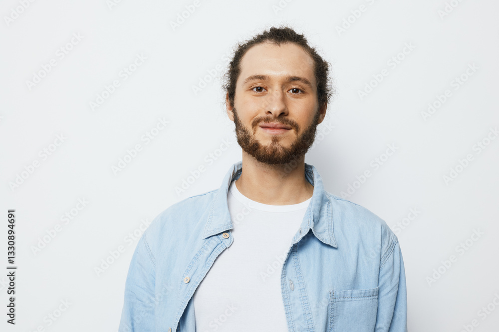 Young man smiling confidently in a light blue shirt against a plain white background, showcasing a positive and approachable demeanor, ideal for lifestyle and portrait photography Young man smiling confidently in a light blue shirt against a plain white background, showcasing a positive and approachable demeanor, ideal for lifestyle and portrait photography