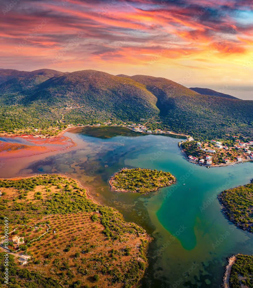 Fantastic summer view of Limin Ieraka village and Riva island. Dramatic sunrise on Peloponnese peninsula, Greece. Beautiful morning seascape of Myrtoan Sea. Traveling concept background.