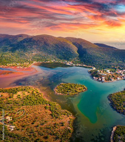 Fantastic summer view of Limin Ieraka village and Riva island. Dramatic sunrise on Peloponnese peninsula, Greece. Beautiful morning seascape of Myrtoan Sea. Traveling concept background.