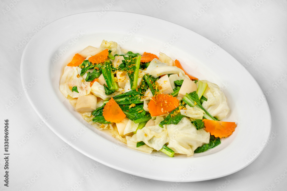 This image shows a white oval plate with stir-fried vegetables, including cabbage, leafy greens, and sliced carrots, garnished with crispy garlic or seasoning. This image shows a white oval plate with stir-fried vegetables, including cabbage, leafy greens, and sliced carrots, garnished with crispy garlic or seasoning.