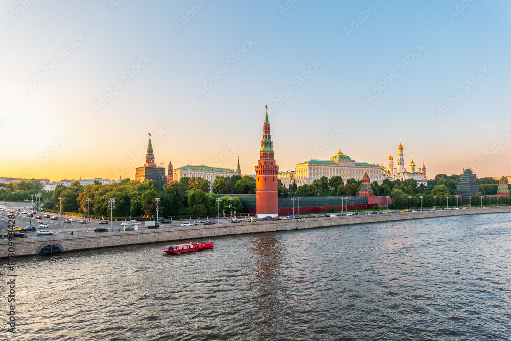 Obraz premium View of Kremlin with Vodovzvodnaya tower, Grand Kremlin Palace from repaired Bolshoy Kamenny Bridge in Moscow city on sunny summer day. Cruise ship sails on the Moscow river