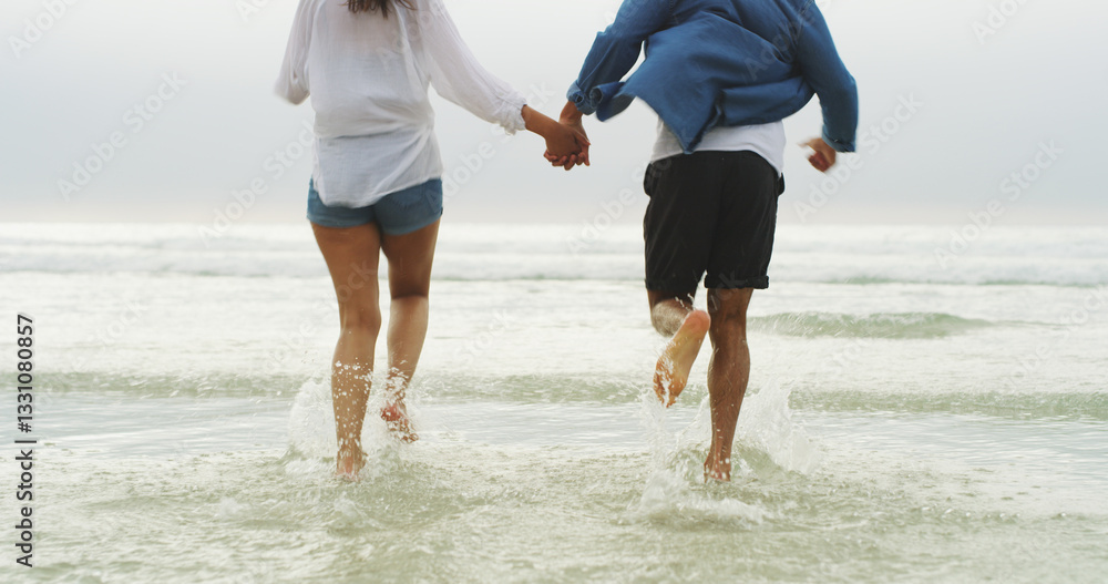 Couple, holding hands and running in water at beach for travel holiday, freedom or support in relationship. Back, legs of people and romantic date by ocean with adventure, trust or honeymoon vacation Couple, holding hands and running in water at beach for travel holiday, freedom or support in relationship. Back, legs of people and romantic date by ocean with adventure, trust or honeymoon vacation