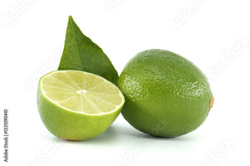 Fresh lime cut in half showing pulp and leaf on white background