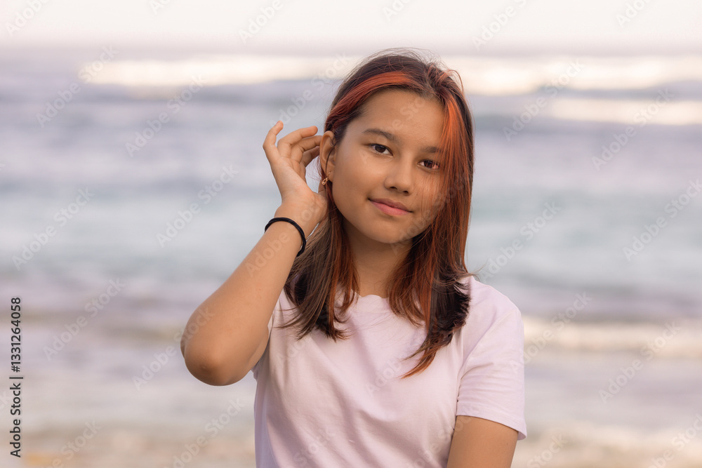 Portrait of Asian teenager girl. Smiling face. Long hair. Hand touching head and hair. Female wearing white T-shirt. Portrait of Asian teenager girl. Smiling face. Long hair. Hand touching head and hair. Female wearing white T-shirt.