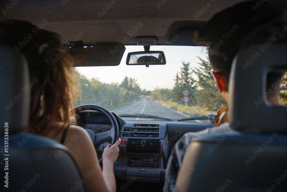 Fototapeta premium A young couple on a self-driving tour, driving on a rural road in the suburbs of Siena, Tuscany, Italy