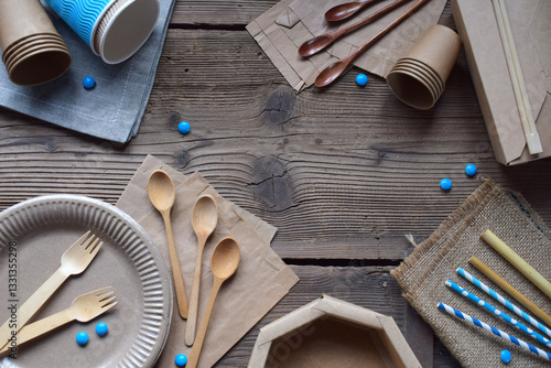 Eco-Friendly Disposable Tableware Made of Wood and Paper on Rustic Wooden Surface. Sustainable Alternative to Plastic Cutlery, Biodegradable Cups, Forks, Spoons, and Straws for Zero-Waste Lifestyle