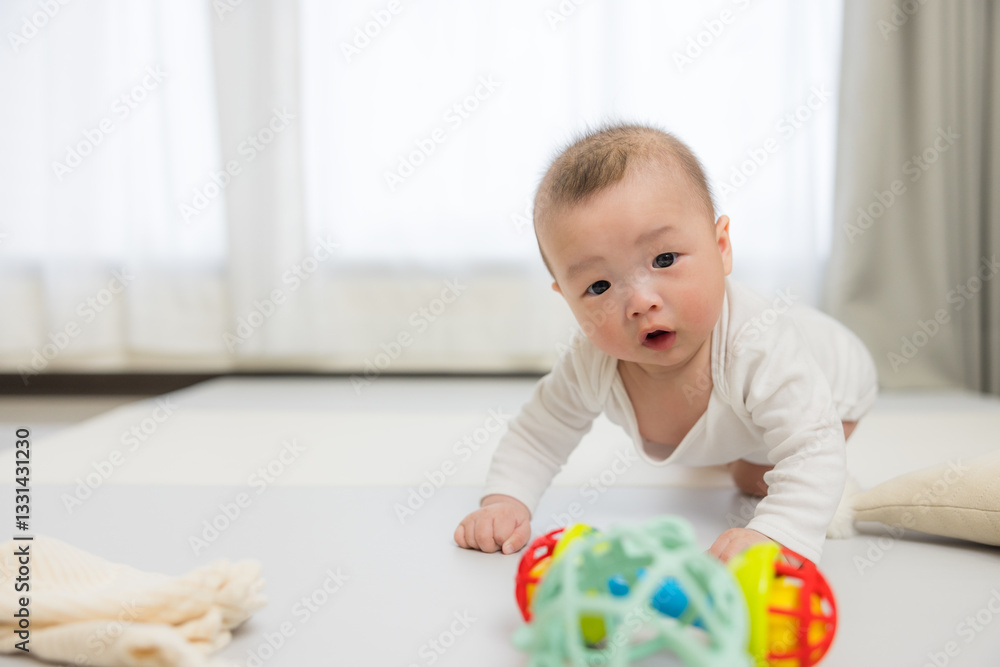 Baby crawling on floor reaching for toy