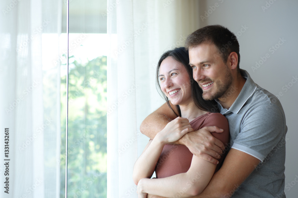 Happy interracial couple looking through a window Happy interracial couple looking through a window