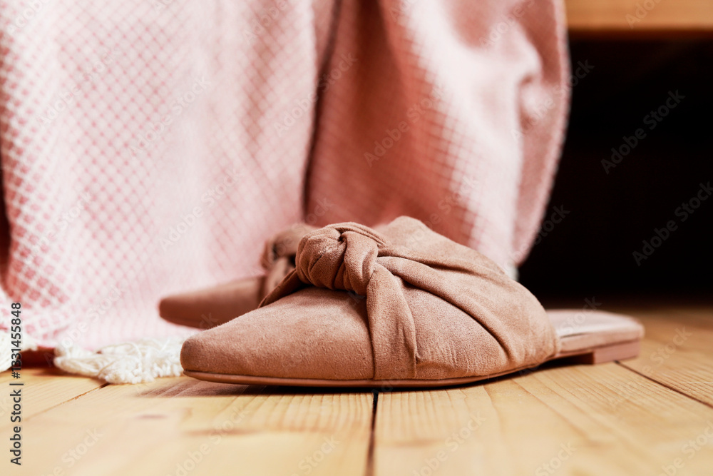 Pink blanket and suede slip-ons on wooden floor. Scandinavian lifestyle.