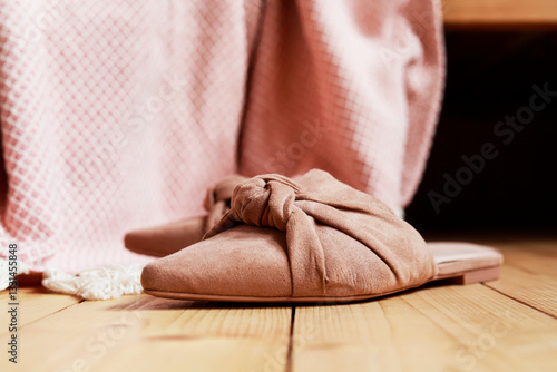 Obraz na płótnie Pink blanket and suede slip-ons on wooden floor. Scandinavian lifestyle. w salonie
