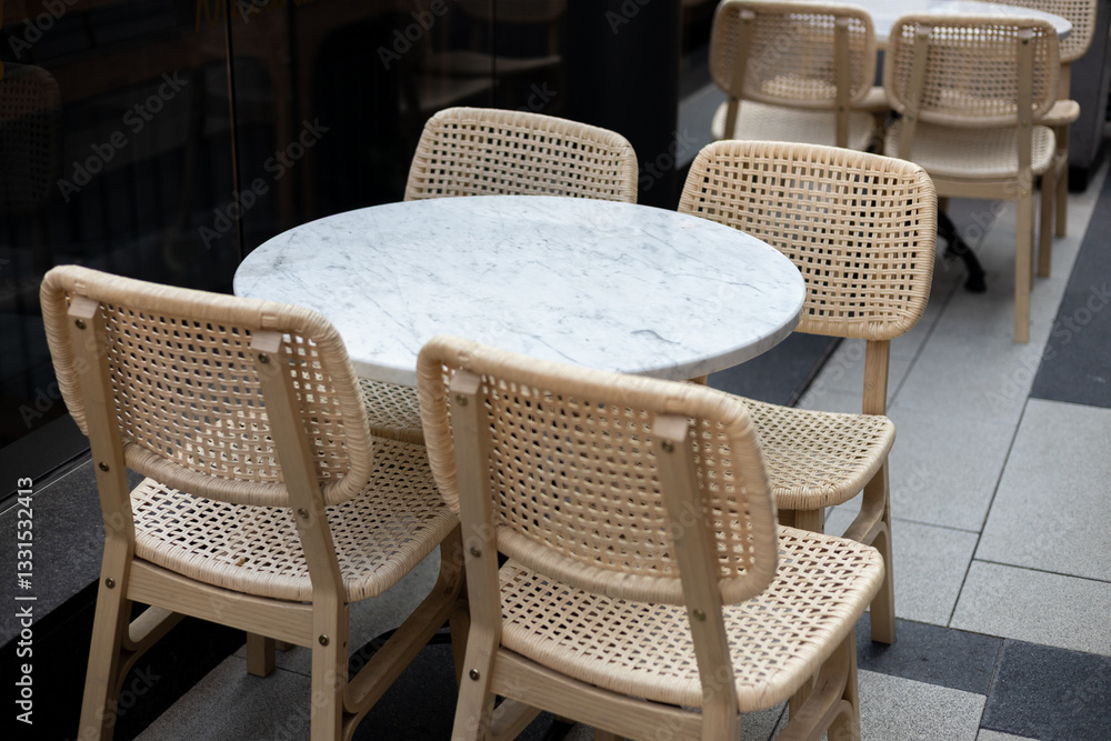 Modern outdoor terrace with seating arrangement. Fashionable outdoor restaurant tables, summer time. Tables and chairs at sidewalk cafe. Touristic setting, cafe table, sidewalk cafe furniture