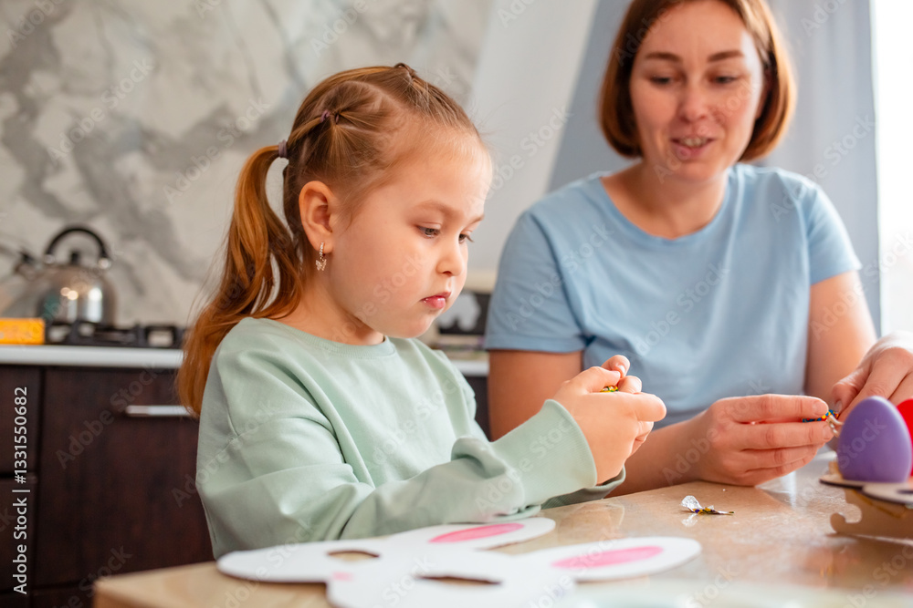 Portrait of cute little daughter and mother makes festive decorations for the spring Easter Portrait of cute little daughter and mother makes festive decorations for the spring Easter