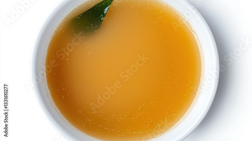 Clear Broth in White Bowl with Leaf Garnish on White Background