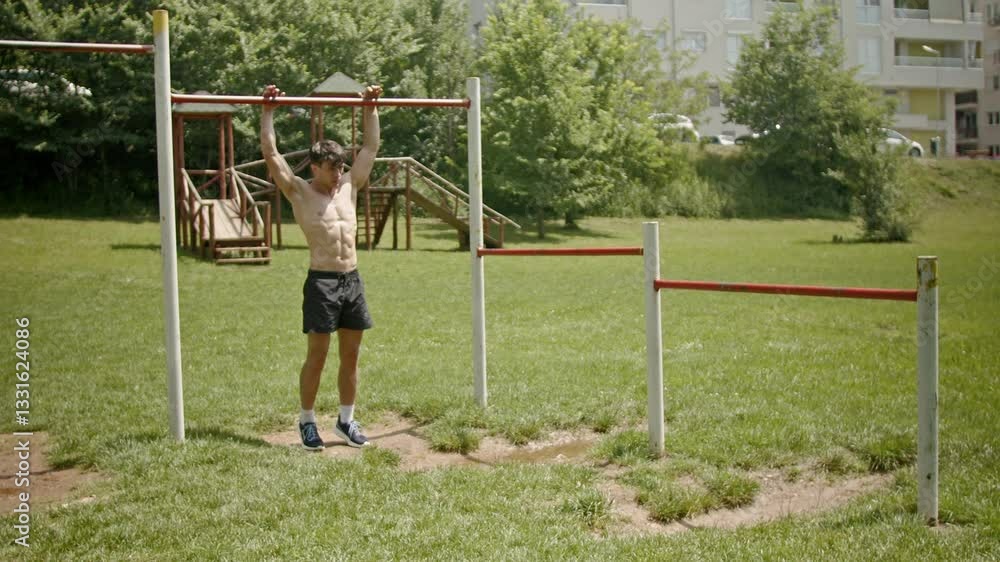 A young muscular man doing pull-ups in an outdoor training park. Fitness, health, and strength training concepts. A young muscular man doing pull-ups in an outdoor training park. Fitness, health, and strength training concepts.