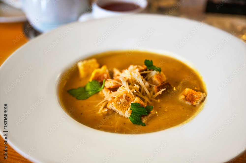 Pumpkin soup with grated cheese with fried bread cube, portion Pumpkin soup with grated cheese with fried bread cube, portion