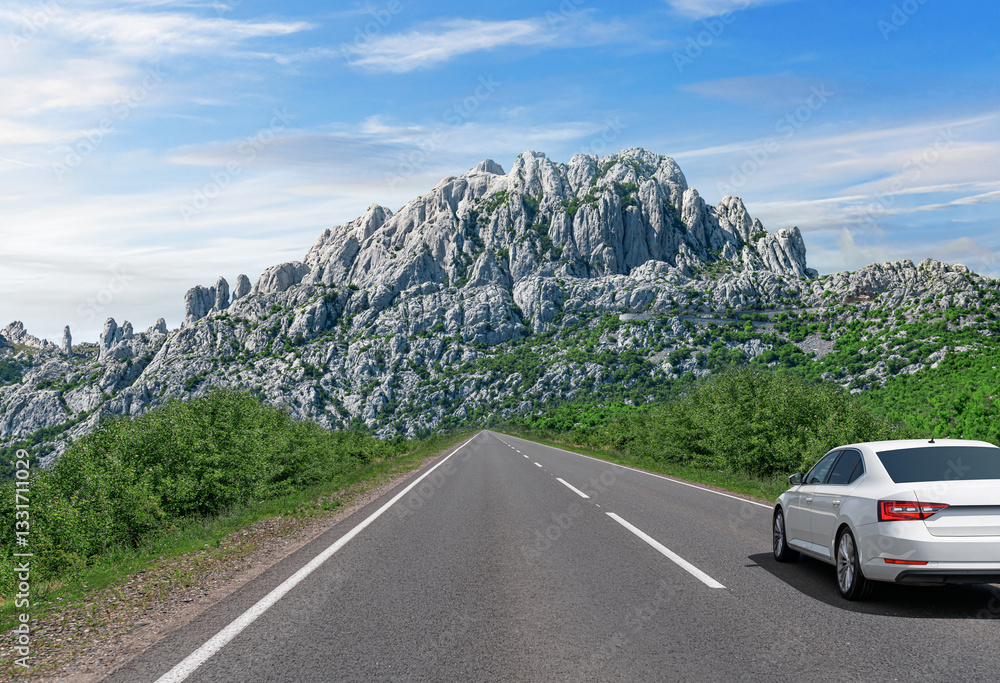 A white car drives along a scenic highway surrounded by lush greenery, heading towards towering rocky mountains under a bright blue sky, capturing the essence of adventure and exploration.