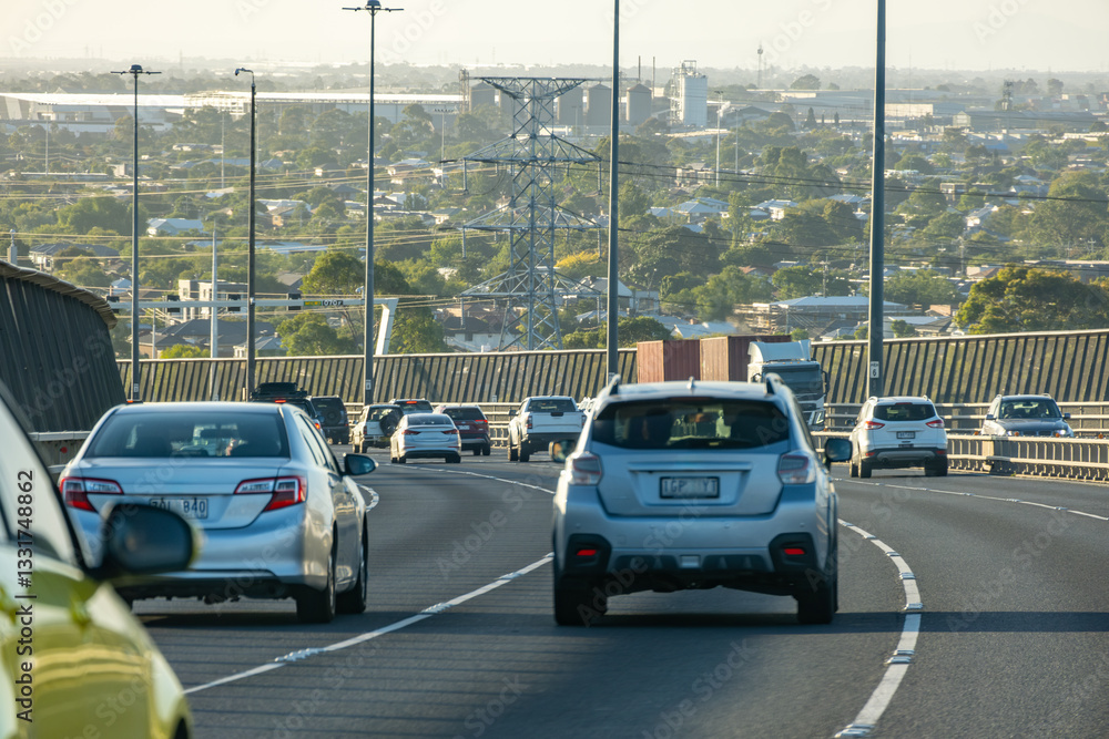 Obraz premium Heavy traffic flows, with cars traveling on the multi-lane West Gate Bridge in Melbourne, Australia, overlooking the cityscape and suburban neighborhoods in the western suburbs.