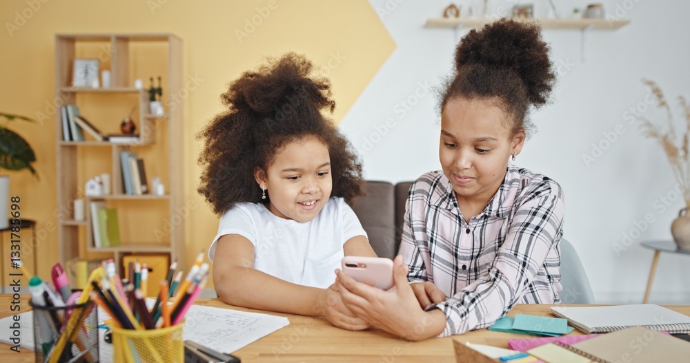 Two sisters joyfully use their smartphones in a bright, warm room full of happiness Two sisters joyfully use their smartphones in a bright, warm room full of happiness