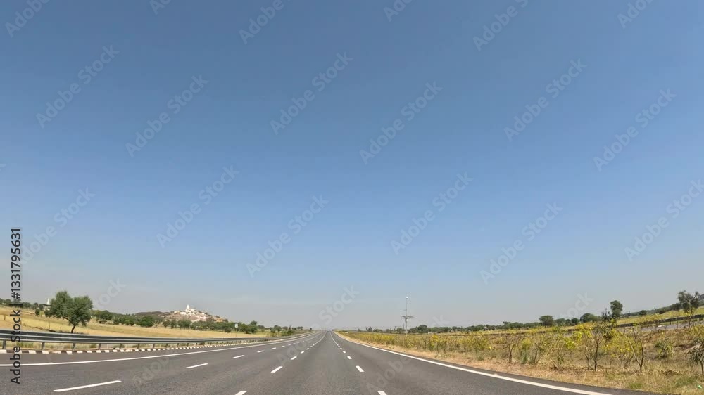 Road seen from moving vehicle on sunny day Road seen from moving vehicle on sunny day
