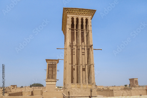 Сlose-up view of wind tower in Yazd, Iran. Several more are visible in background. These towers are informal symbol of city. Since ancient times, they have been used to cool air inside buildings