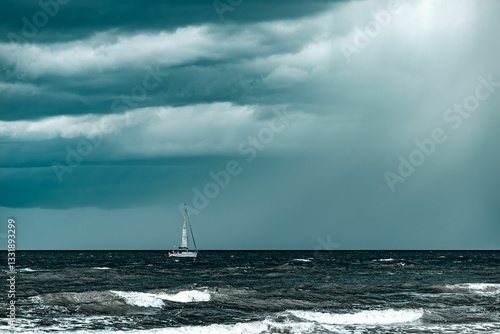 Obraz na plátně Sailboat on choppy sea under dramatic sky.