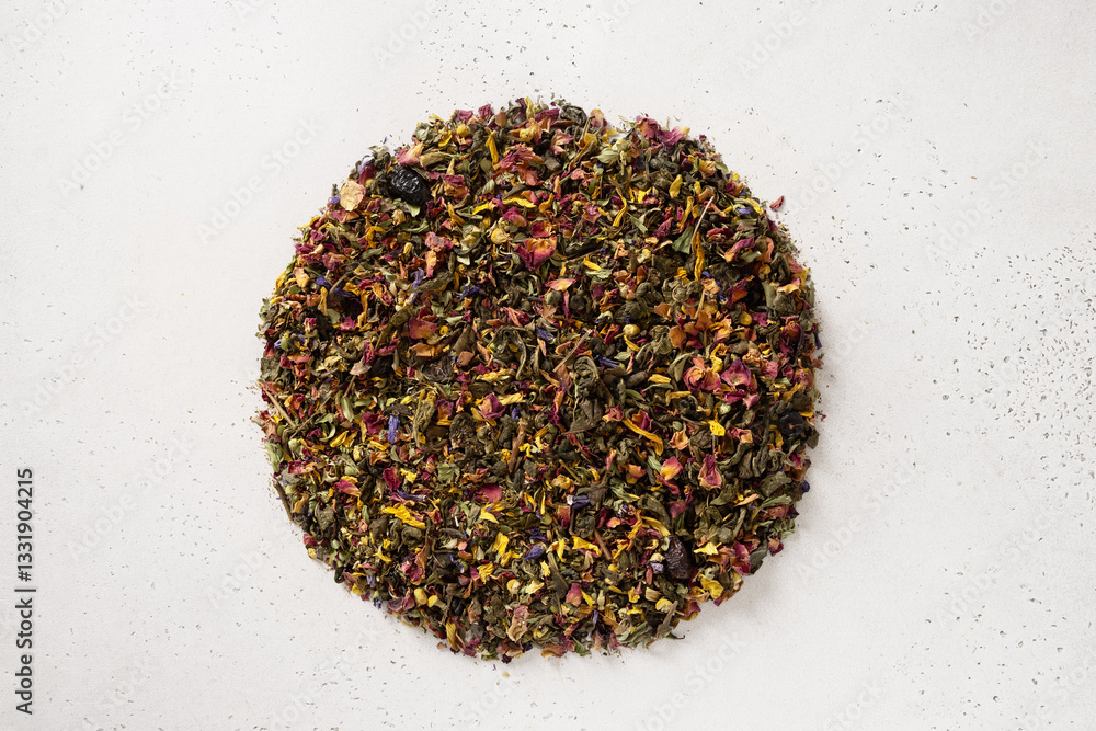 Pile of dry herbal tea and flowers green tea in shape of circle on white background. View from above. Dry tea leaves texture.