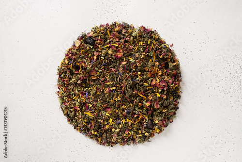 Obraz na płótnie Pile of dry herbal tea and flowers green tea in shape of circle on white background. View from above. Dry tea leaves texture. w salonie