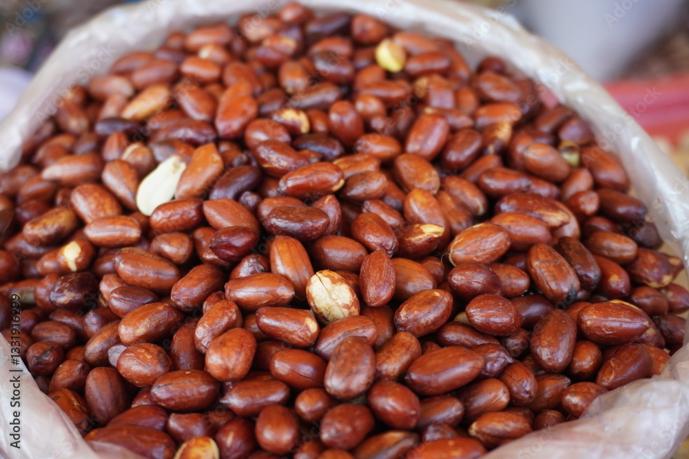 A pile of roasted spicy peanuts are displayed in a market setting likely for sale A pile of roasted spicy peanuts are displayed in a market setting likely for sale