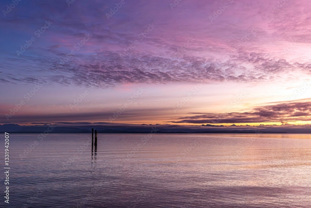 Fototapeta premium Serene coastline view captures the stunning colors of the sunrise at Oyster Bay Shoreline Park